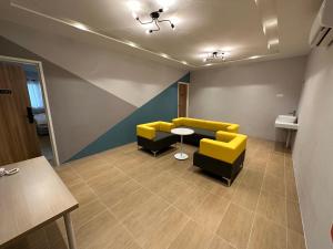 a waiting room with yellow and black chairs and a table at A1 Hotel Sungai Petani in Sungai Petani +74 photos