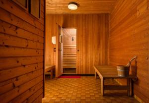 a wooden room with a bench and a door at Strandhotel Habich in Krumpendorf am Wörthersee