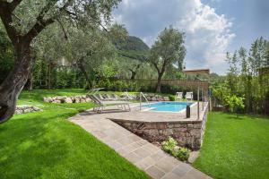 een zwembad in een tuin met een bankje ernaast bij Villa Fani-Wellness & Relax in Malcesine