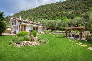 une maison avec une cour dotée d'une pelouse verdoyante dans l'établissement Villa Fani-Wellness & Relax, à Malcesine