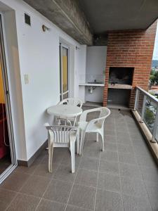 a patio with a table and chairs on a balcony at El Fortín de los Perales in San Salvador de Jujuy