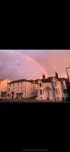a rainbow in the sky over some houses at Vine Cottage - Sandgate in Sandgate