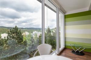 een kamer met een groot raam met een tafel en stoelen bij Czech Family Home in Český Krumlov