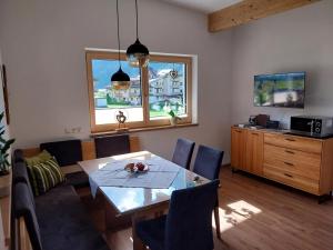 een woonkamer met een tafel en stoelen en een televisie bij Apart Anna in Mayrhofen