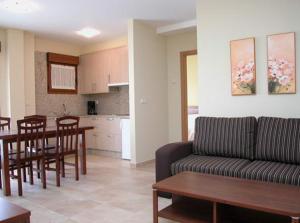 salon z kanapą i stołem oraz kuchnia w obiekcie Sanxenxorural - Apartamentos La Rana w mieście Sanxenxo +31 zdjęć