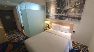 a bedroom with a white bed and a painting on the wall at Travelodge Myeongdong Euljiro in Seoul