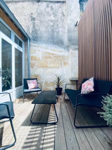 a patio with two chairs and a coffee table at La King Le 50 Suites and SPA in Bordeaux