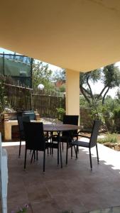 a dining table and chairs on a patio at Dino&Fanny Villasimius in Villasimius