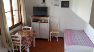 um pequeno quarto com uma mesa e cadeiras e uma escada em Dino&Fanny Villasimius em Villasimius