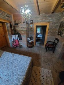 a bedroom with a large bed and a stone wall at Imanje sa bazenom in Obrenovac