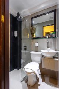 a bathroom with a toilet and a sink and a mirror at NEST NANO SUITES POBLACION-MAKATI in Manila