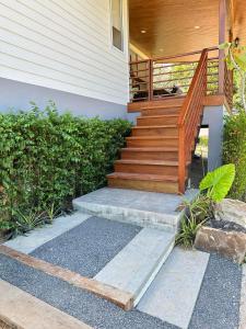 a house with a wooden staircase leading to a porch at The Little Waterfall Phangan in Thong Nai Pan Noi