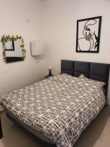 a bedroom with a bed with a black and white comforter at הדירה של עדן in Tel Aviv