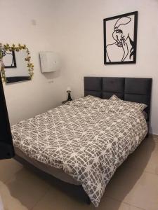 a bedroom with a bed with a black and white comforter at הדירה של עדן in Tel Aviv