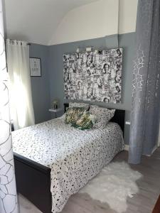 a bedroom with a bed with a black and white comforter at Chez Monique et Jean-Claude in Pézarches