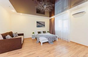 1 dormitorio con cama, sofá y lámpara de araña en Уютные апартаменты на Позняках, en Kiev