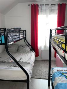 a bedroom with two bunk beds and a window at Chez Monique et Jean-Claude in Pézarches