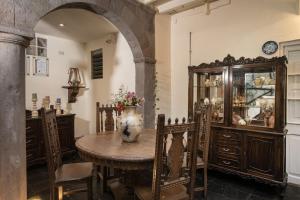 una sala da pranzo con tavolo e mobile di porcellana di Casa Cavassa Centro Histórico Cusco a Cuzco