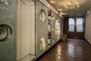 a hallway with a chandelier and walls with mirrors at Casa Cavassa Centro Histórico Cusco in Cusco