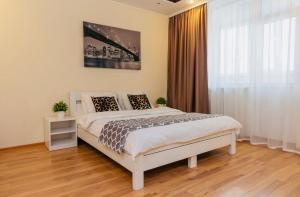 Un dormitorio con una cama y una ventana grande. en Уютные апартаменты на Позняках, en Kiev