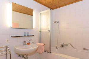 ein weißes Bad mit einem Waschbecken und einer Dusche in der Unterkunft Apparthaus Vonbank in Schruns-Tschagguns