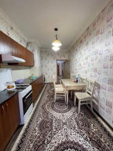 a kitchen with a table and chairs in a room at Three bedroom apartment with 2 showers in Tashkent