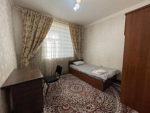 a small room with a bed and a chair at Three bedroom apartment with 2 showers in Tashkent