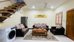 a living room with couches and a washer at A Luxury Duplex in Dili City, Timor-Leste in Dili