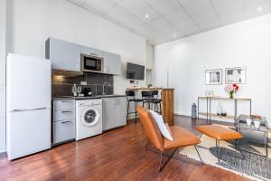 a kitchen with a white refrigerator and a table and chairs at Sweet Inn - Ponthieu V in Paris