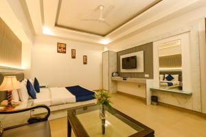 a hotel room with a bed and a glass table at Hotel Krishna Deluxe-By RCG Hotels in New Delhi