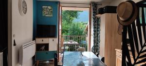 a living room with a door open to a balcony at Pour cure et ski in Luchon