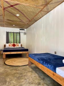 a bedroom with two beds in a room at Dawn Patrol Siargao in General Luna