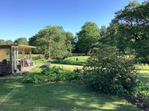 un jardin avec un kiosque et un champ dans l'établissement Enghaven Bed & Kitchen, à Ansager