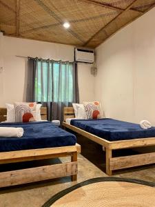 a room with two beds and a window at Dawn Patrol Siargao in General Luna