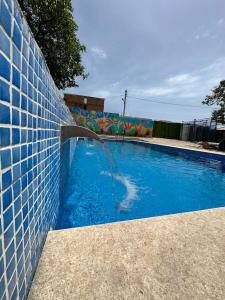una piscina con una fuente en una pared de azulejos en Гостевой дом Асель en Cholpon-Ata