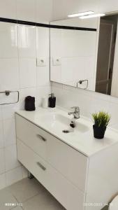 a white bathroom with a sink and a mirror at Aguazul - A pie de piscina y vistas al mar in Puerto del Carmen
