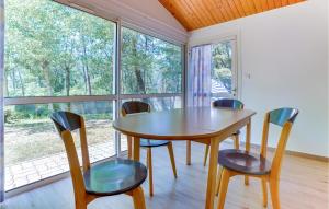 ein Esszimmer mit einem Tisch, Stühlen und Fenstern in der Unterkunft Amazing Home In La Faute-sur-mer With Heated Swimming Pool in La Faute-sur-Mer