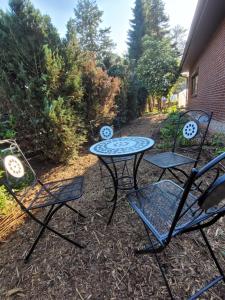 a patio with three chairs and a table at Monteurzimmer Noack in Uetze