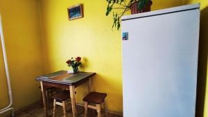 a small table with a vase of flowers and a refrigerator at Василя Стуса 10 City Rooms in Bila Tserkva