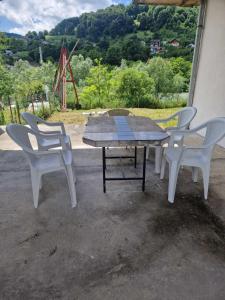 een picknicktafel en stoelen met uitzicht op een veld bij Apartman Sofija in Banja Luka