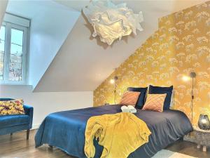 - une chambre avec un lit bleu et un mur jaune à motifs dans l'établissement Maison Chic & charme Calme avec Jardin, au Mans