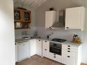 a kitchen with white cabinets and a stove top oven at Monte Teu in São Luis