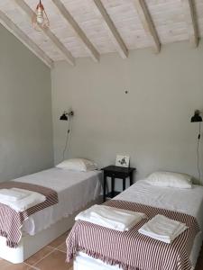 two beds in a room with white walls at Monte Teu in São Luis