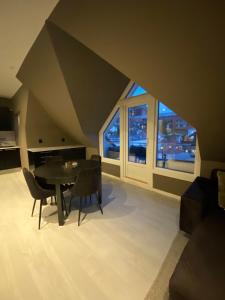 a dining room with a table and a large window at Penthouse with private balcony in the city centre of Bergen in Bergen