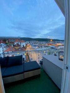 a balcony with a couch and a view of a city at Penthouse with private balcony in the city centre of Bergen in Bergen