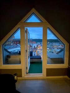 a room with a window with a view of a city at Penthouse with private balcony in the city centre of Bergen in Bergen