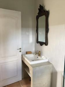 a white bathroom with a sink and a mirror at Monte Teu in São Luis