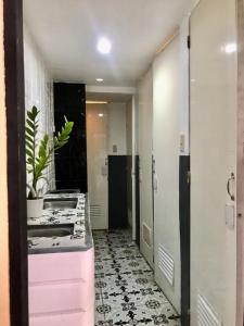 a hallway with a kitchen with a pink counter at Budget Transient Capsule Room Makati near Ayala and Buendia in Manila