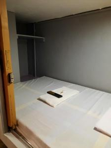 マニラにあるBudget Transient Capsule Room Makati near Ayala and Buendiaのベッド(上に携帯電話付)