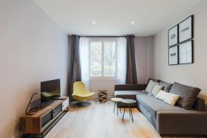 uma sala de estar com um sofá e uma televisão em 2 pieces proche metro, Montrouge em Montrouge